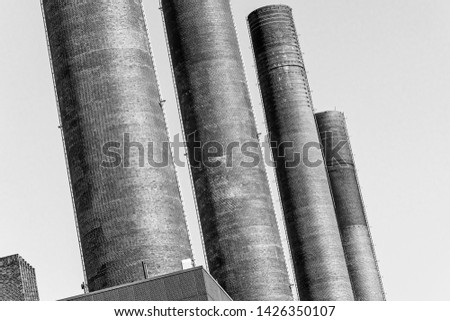 Abstract deliberately crooked image of the chimneys of the power plant of a large industrial plant, oblique