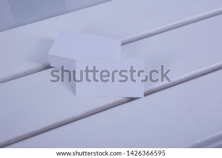 Blank business cards on white wooden background.