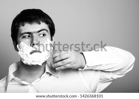 Surprised man shaving. Image in black and white color