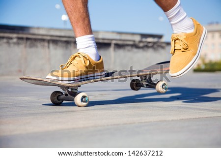 Close up of a skateboarders feet while skating on concrete at the skate park
