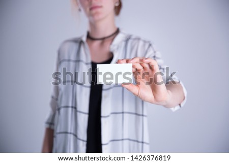 Young woman hand showing blank white visiting card.