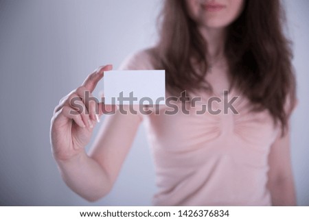 Young woman hand showing blank white visiting card.