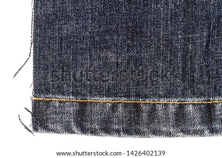 Piece of dark jeans fabric isolated on white background. Rough uneven edges.