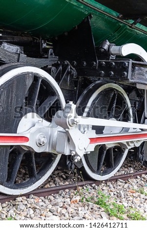 large white iron wheels of an old locomotive close-up vertical photo