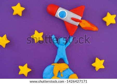 Person standing on Earth and launching space rocket into space. Person, planet Earth and Space Rocket are made out of play clay (plasticine).