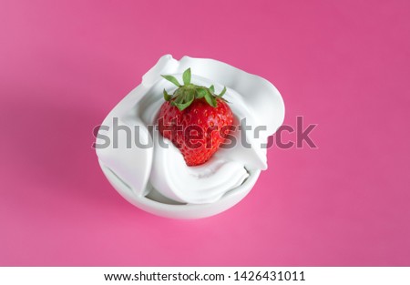 bowl of red strawberries on soft white milk cream on pink background