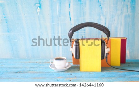 audio book concept with book, headphones and cup of coffee, panorama format on grungy background, good copy space