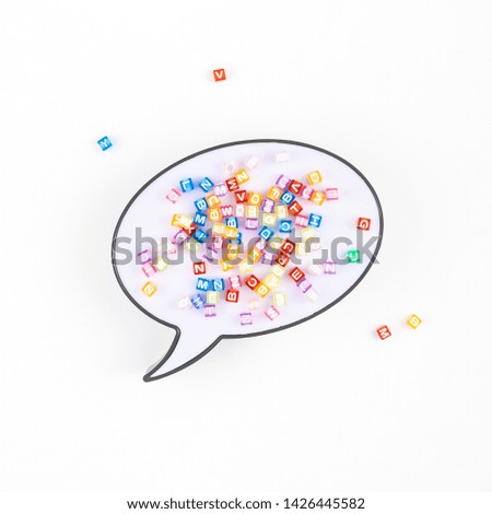 Creative flat lay back to school education concept with speech bubble lightbox and multicolor letters isolated on white background with copy space, template for text or design