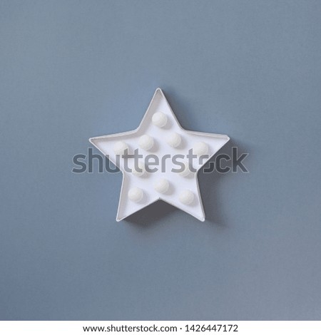 Star shaped white LED lights lamp single frame. Creative conceptual top view flat lay square composition with copy space on grey background in minimal style. Ultimate Gray