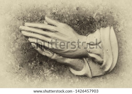 religious symbol of praying hands on a memorial tomb stone, vintage look