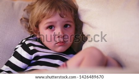 Child watching TV screen. Portrait close-up of young boy staring screen at night