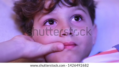 Child watching TV screen. Portrait close-up of young boy staring screen at night