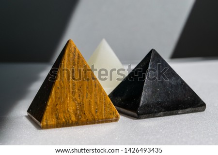 Shungite, opal and tiger eye stone, pyramids of mineral
