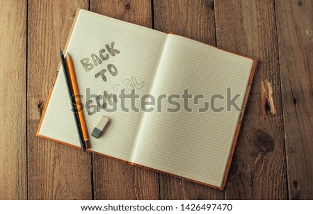 Back to school, the concept of raising children. Day of knowledge. Notebook in a slanting line on a wooden table with space for text. Copy space. Rustic and vintage toning.