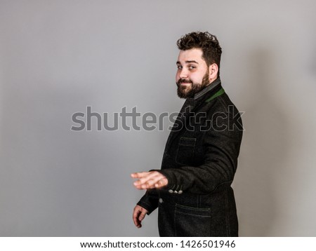 cool man with traditional costume is posing in front of grey background