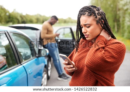 Female Motorist Involved In Car Accident Calling Insurance Company Or Recovery Service Royalty-Free Stock Photo #1426522832
