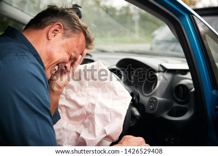 Male Motorist Injured In Car Crash With Airbag Deployed Royalty-Free Stock Photo #1426529408