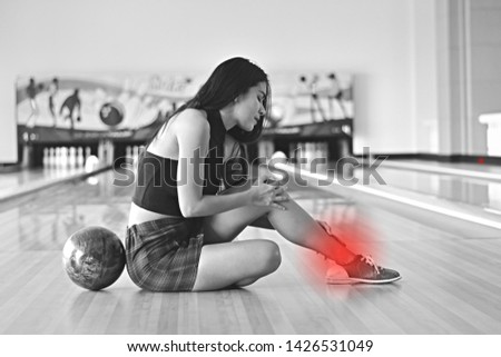 Asian woman ankle pain in Bowling alley, Black and white tone
