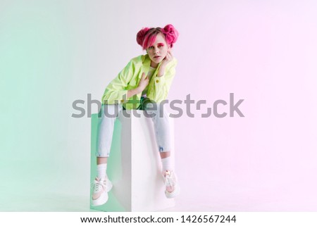 woman with pink hair sits on a cube retro style fashion