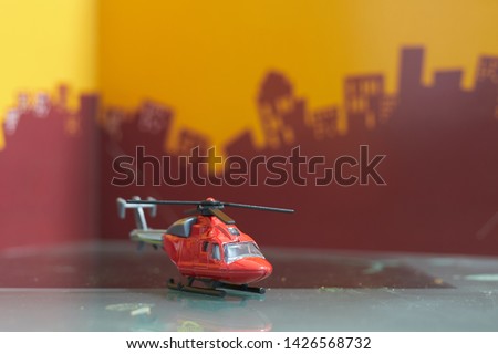 Red toy single  blade helicopter on blur city background