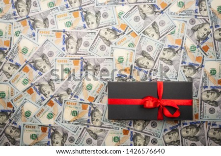 Black gift boxes with bow on background of dollars. top view, copy space