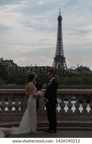 A couple get married with the Eiffel Tower in the background.