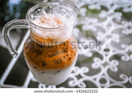 Iced macchiato on glass table background.