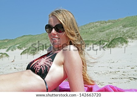 Beautiful blonde woman relaxing at the beach in the Netherlands