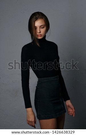 Test shooting for glorious young woman wearing denim skirt and black sweater
