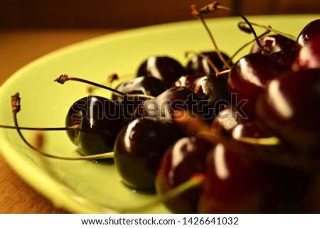 summer photo of ripe cherries on a green plate