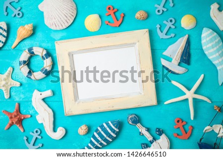 Summer background with frame and nautical decorations on wooden table. Top view from above