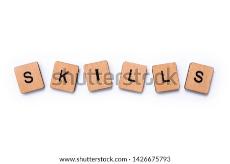 The word SKILLS, spelt with wooden letter tiles over a white background.