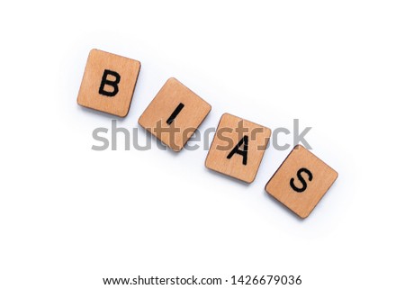 The word BIAS, spelt with wooden letter tiles over a white background.