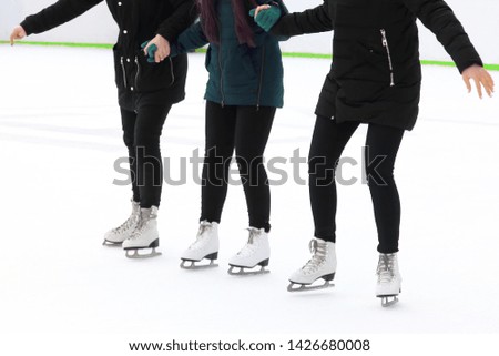three girls holding hands ice-skating on the ice rink. sports, Hobbies and recreation of active people

