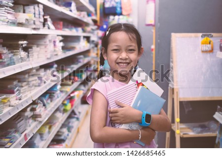 Asian Student in stationery store buying notebook with smile and happy.Back to school concept