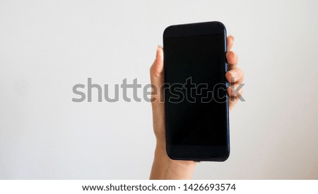 Isolated female hand holding a phone with black screen