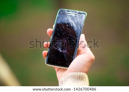 young man hold broken smartphone screen. Broken phone screen in hand