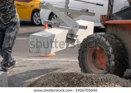 Installing pavement curb level and rubber hammers.