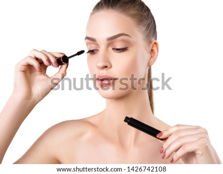 Beautiful woman applying mascara on her eyelashes Royalty-Free Stock Photo #1426742108