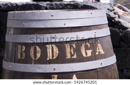 Close up of wooden wine barrel with text Bodega in front of natural stone wall - Lanzarote