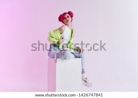 woman with pink hair sits on a cube retro style fashion