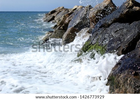 Wave breaking in the rocks of the breakwater. Water breaking in waves
