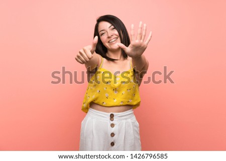 Young Mexican woman over isolated wall counting six with fingers