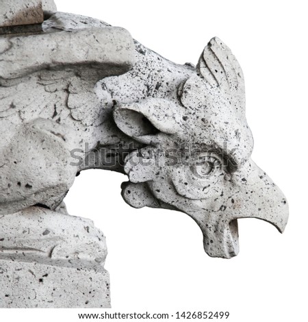 The gargoyle made of stone, ancient animalistic statue looking down, isolated on white