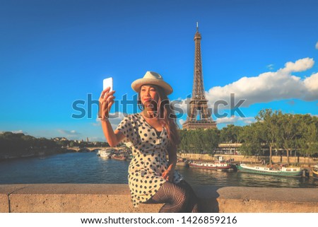 Happy travel asian woman enjoy her  vacation in Paris, she loves taking selfies with Eiffel Tower, asian beauty