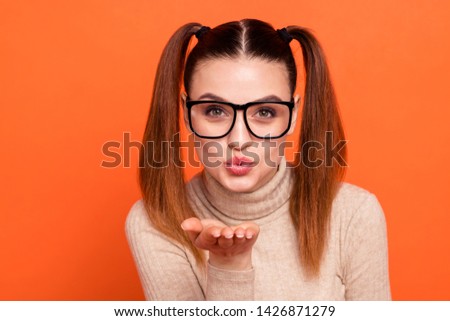 Close up photo attractive charming lady candid send air kisses boys romance dream love cute date valentine day sweet attractive childish eyewear eyeglasses turtleneck isolated orange background