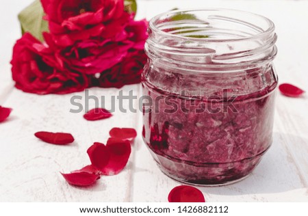 Jam of rose petals in a glass jar on a light background. Flower confiture. Healthy food. Copy space