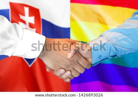 Business handshake on the background of two flags. Men handshake on the background of the Slovakia and LGBT gay flag. Flag of tolerance. Support concept
