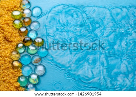 coarse sand with transparent stones on the background of blue clear water. summer concept. imitation of the beach.