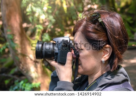 woman photographer taking picture in a forest